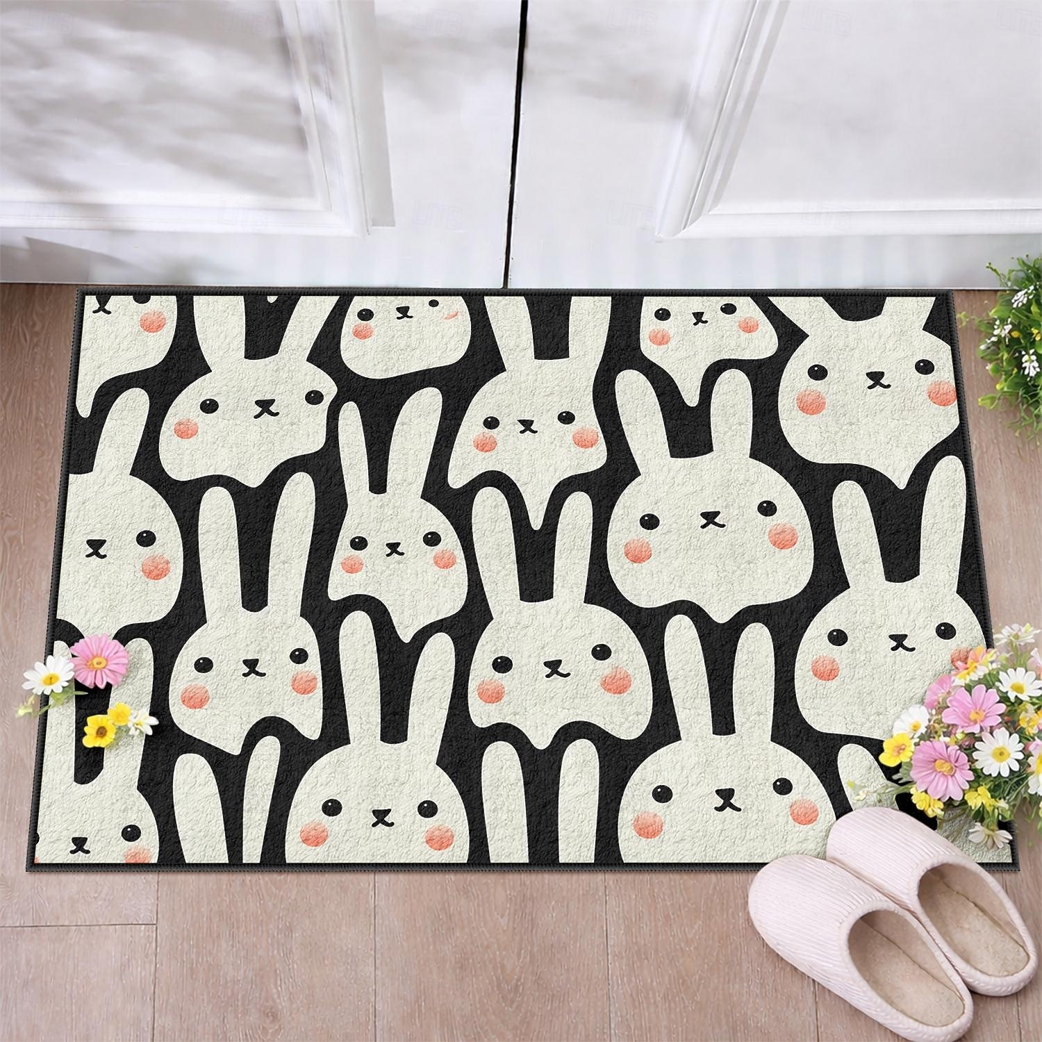 Felpudo de Pascua con una divertida cara de conejo en blanco y negro y lindas mejillas sonrosadas, ideal para la entrada festiva de Pascua. 2026 - $16.99 –P2