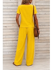  Conjunto feminino de duas peças texturizado, composto por blusa assimétrica de manga curta com decote quadrado e botões, calça pantalona de cintura alta com botões decorativos na barra e um elegante