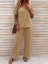  Conjunto feminino de duas peças texturizado, composto por blusa assimétrica de manga curta com decote quadrado e botões, calça pantalona de cintura alta com botões decorativos na barra e um elegante