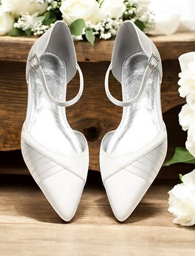  Sandalias de boda planas de satén blanco con punta puntiaguda, correa en el tobillo y elegantes detalles plisados para ocasiones nupciales.