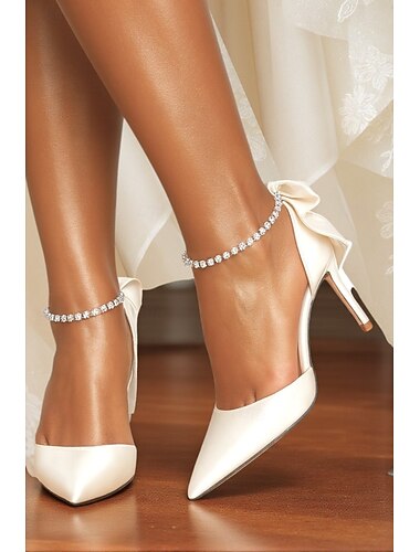  Damesko med elfenbensfarget sateng, spiss tå, stiletthæler med sløyfe og strass-ankelrem - elegante sko til bryllup og formelle anledninger