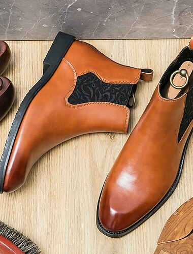 Мужские коричневые ботинки челси из искусственной кожи – элегантные и удобные, идеально подходят для официальных мероприятий и элегантно-повседневных случаев.   Мужские коричневые ботинки челси из искусственной кожи – элегантные и удобные, идеально подходят для официальных мероприятий и элегантно-повседневных случаев.