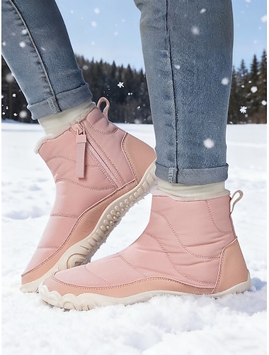  フェイクファーのトリムが付いたピンクの断熱冬用ブーツ。冬のアクティビティ、雪の日、アウトドアの探検に最適な暖かく機能的なブーツです。