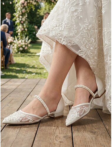  Chaussures de mariée plates élégantes et confortables pour femme, ornées de dentelle ivoire et de perles, idéales pour un mariage en extérieur, par exemple dans un jardin.