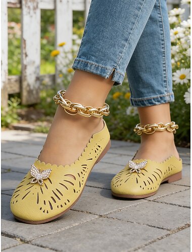  Damesmuiltjes in geel met een brede pasvorm en een vlinderdetail van strasssteentjes. Deze stijlvolle en comfortabele instapschoenen zijn perfect voor dagelijks gebruik, lente-/zomeruitjes, ontspannen wandelingen en buitenactiviteiten.