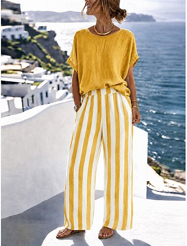  Completo coordinato da donna a due pezzi: top a maniche a pipistrello con scollo rotondo, righe verticali, vita alta, gamba larga, pantaloni palazzo, outfit casual estivo per le vacanze.